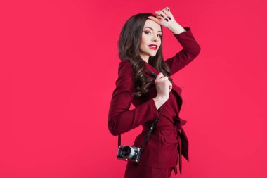Son moda blogger pembe bir arka plan üzerinde. Kamera ile genç kadın