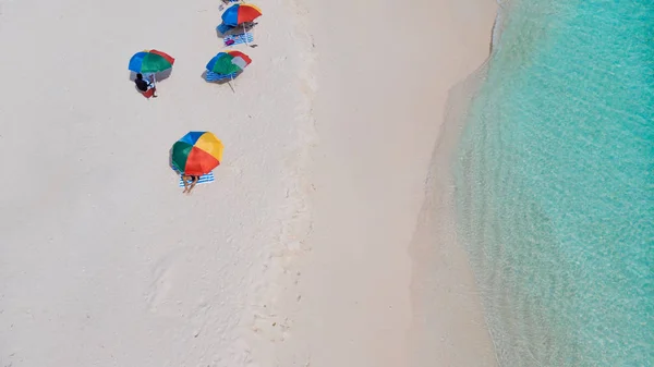 Colorful umbrellas for protection from the sun on the beach. Clear sea and white sand