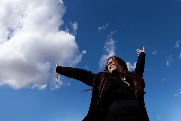 Happy young brunette in black clothes enjoys freedom — Stock Photo, Image