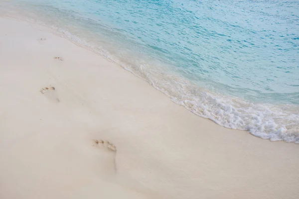 Huellas en la arena. Isla tropical paradisíaca, arena blanca y agua clara . — Foto de Stock