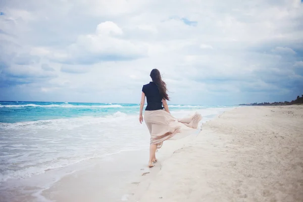 Young woman in a long skirt walking on the ocean. — Stock Photo, Image