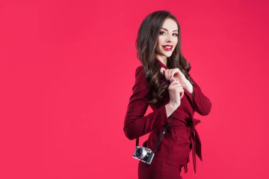 Son moda blogger pembe bir arka plan üzerinde. Kamera ile genç kadın
