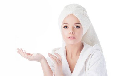 Duştan sonra krem kullanmak için. Bornoz ve havlu başında genç bir çekici kadın portresi.