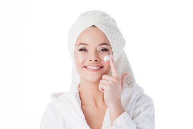 Duştan sonra krem kullanmak için. Bornoz ve havlu başında genç bir çekici kadın portresi.