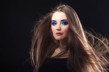 Parlak şık makyajlı çekici esmer. Renkli Smokey eyes ve mavi kaşları.