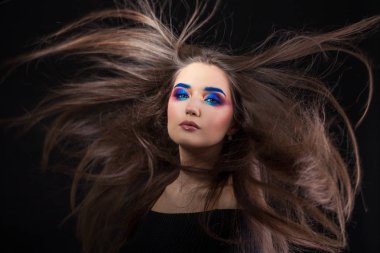 Parlak şık makyajlı çekici esmer. Renkli Smokey eyes ve mavi kaşları.