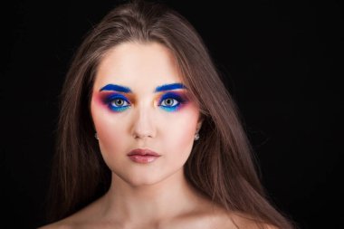 Parlak şık makyajlı çekici esmer. Renkli Smokey eyes ve mavi kaşları.