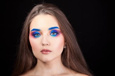 Parlak şık makyajlı çekici esmer. Renkli Smokey eyes ve mavi kaşları.