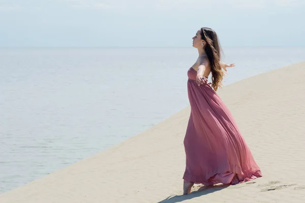 紅光のドレスの若いブルネットは、自然を楽しんでください。. — ストック写真