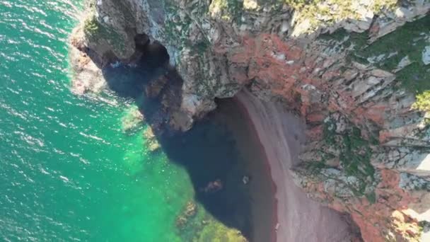 海の中の急な岩の崖の景色。青い海と岩の多い海岸、ドローンのすばらしい眺め — ストック動画