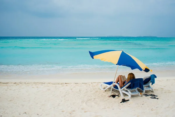 熱帯の島の残りの部分します。傘の下、ビーチでサンラウン ジャーであります。 — ストック写真