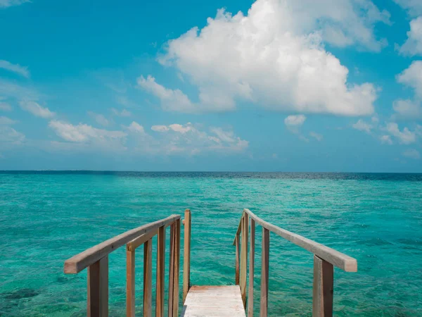 青い海と空の素晴らしい背景の海に木製の桟橋を拡張します。. — ストック写真