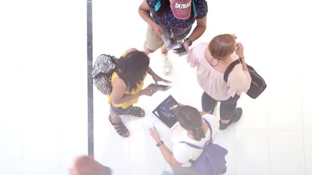 Dubai, Birleşik Arap Emirlikleri, 1 Mayıs 2018: Rating insanların alışveriş merkezinde. bir grup insan onların rota, üstten görünüm yapmak için haritalar ve akıllı telefonlar kullanmak — Stok video