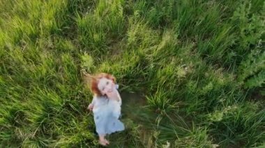 Sahada bak dönmektedir mutlu sarışın genç kadın