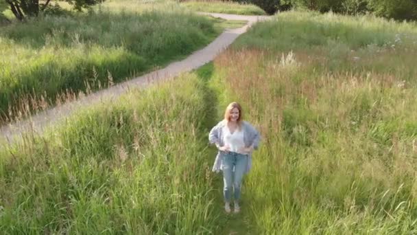 Rolig ung kvinna gående längs vägen. Fältet — Stockvideo