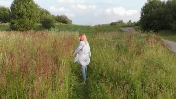 A rapariga corre pelo campo. Jovem feliz correndo junto — Vídeo de Stock