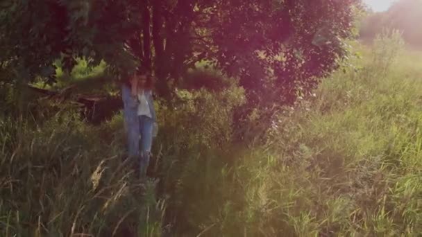 La chica va bajo el árbol. Una joven caminando en el campo — Vídeo de stock