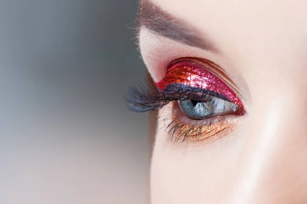 Amazing Bright eye makeup in luxurious red arrow. Red and gold shining tones, eye shadow. — Stock Photo, Image