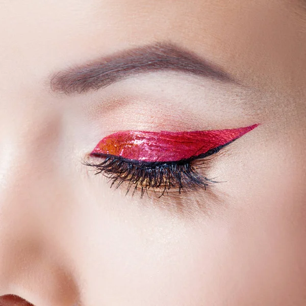 Amazing Bright eye makeup in luxurious red arrow. Red and gold shining tones, eye shadow. — Stock Photo, Image