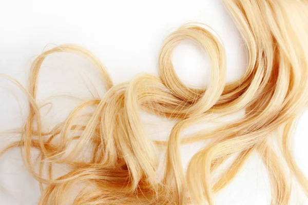 Golden Curls cabelo isolado no fundo branco. fio de cabelo loiro ou ruivo, cuidado do cabelo — Fotografia de Stock