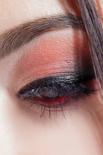 Verbazend helder oog make-up met een grote pijl. Bruine en rode tinten, gekleurde oogschaduw. — Stockfoto