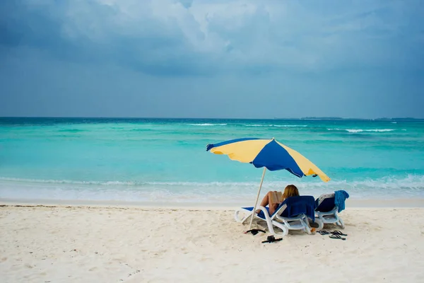 Rest on a tropical island. Lie in a sun lounger on the beach under an umbrella — Stock Photo, Image