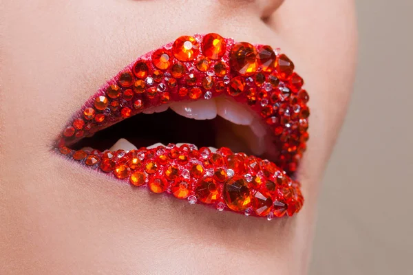 Labios rojos cubiertos de pedrería. Hermosa mujer con lápiz labial rojo en los labios — Foto de Stock