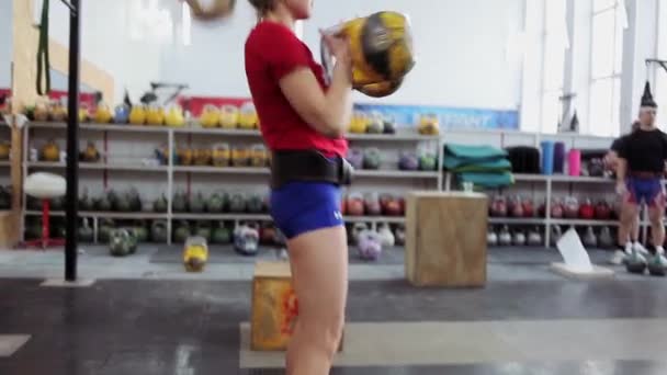 Joven atleta realiza un largo ciclo de empuje con kettlebell. Chica en el gimnasio haciendo ejercicios de fitness y deportes con pesas — Vídeos de Stock