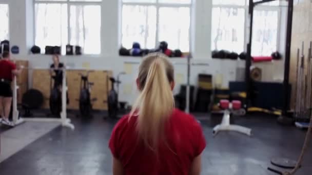 Jeune athlète femme effectue un long cycle pousser avec kettlebell. Fille dans la salle de gym faire des exercices de fitness et de sport avec des kettlebells — Video