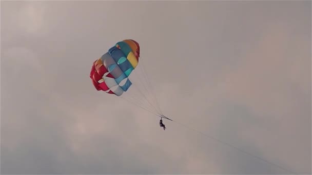 Parasailen in avond. Bright parachute op een achtergrond van een hemel. — Stockvideo