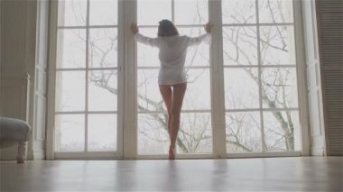 Beyaz bir gömlek penceresinde güzel genç kadın. dans ve rahatlatıcı