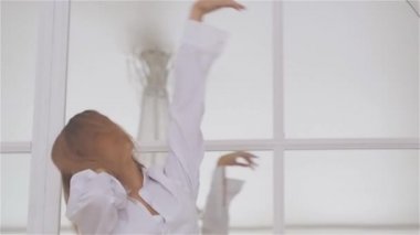 Beyaz bir gömlek penceresinde güzel genç kadın. dans ve bale Barre adlı dans salonunda rahatlatıcı