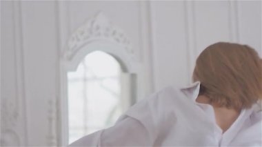 Beyaz bir gömlek penceresinde güzel genç kadın. dans ve bale Barre adlı dans salonunda rahatlatıcı