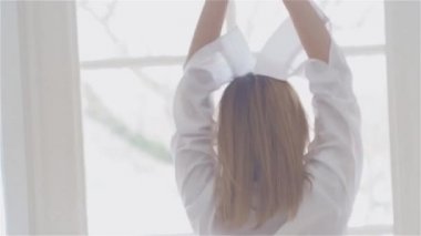 Beyaz bir gömlek penceresinde güzel genç kadın. dans ve rahatlatıcı