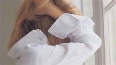 Beyaz bir gömlek penceresinde güzel genç kadın. dans ve rahatlatıcı