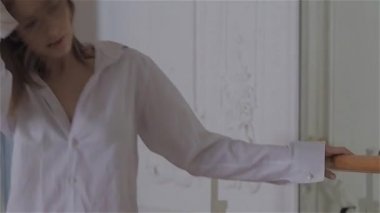 Beyaz bir gömlek penceresinde güzel genç kadın. dans ve bale Barre adlı dans salonunda rahatlatıcı