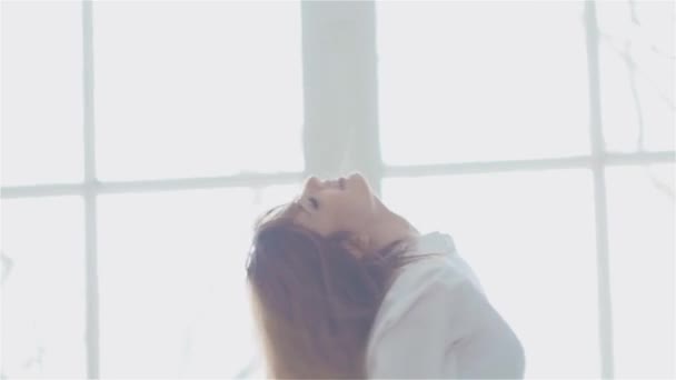 Gyönyörű fiatal nő az ablak fehér ing. tánc és pihentető — Stock videók