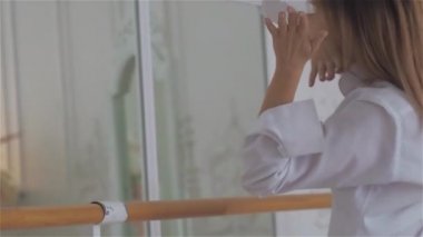 Beyaz bir gömlek penceresinde güzel genç kadın. dans ve bale Barre adlı dans salonunda rahatlatıcı