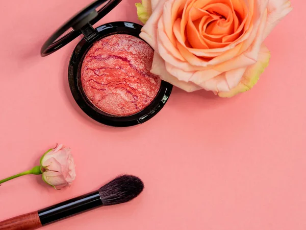 Powder or highlighter in a round package on a pink background with a flower. — Stock Photo, Image