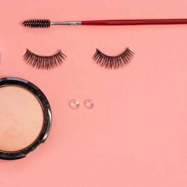 Güzel bir yüz olarak kirpik, toz ve Kaş fırçası, pembe arka planda kavramı.