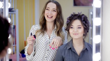 Stilist makyaj sanatçısı bir güzellik salonunda makyaj ve saç yapıyor. Profesyonel makyaj