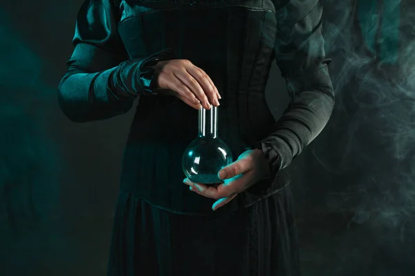 Die Frau ist Forscherin und hält eine Flasche mit dem Material in der Hand. Konzept der wissenschaftlichen Forschung und Wissenschaftsgeschichte. — Stockfoto
