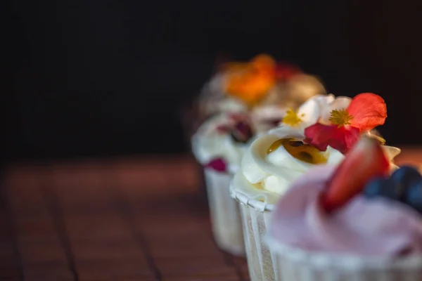Piękne i pyszne Cupcakes na stole. Zestaw pysznych słodkich deserów — Zdjęcie stockowe