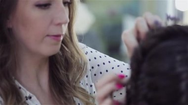 Stilist makyaj sanatçısı bir güzellik salonunda makyaj ve saç yapıyor. Profesyonel makyaj