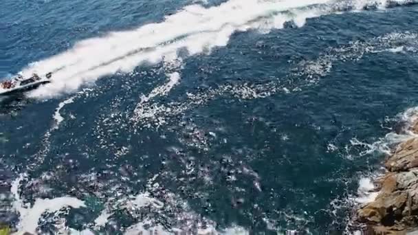 Speedboot segelt in der Nähe der felsigen Küste. Blick auf die steile Felsklippe im Meer. atemberaubende Aussicht auf das blaue Meer — Stockvideo