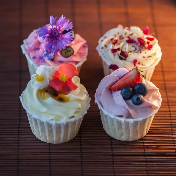 Bonitos e deliciosos cupcakes na mesa. Um conjunto de deliciosas sobremesas doces — Fotografia de Stock
