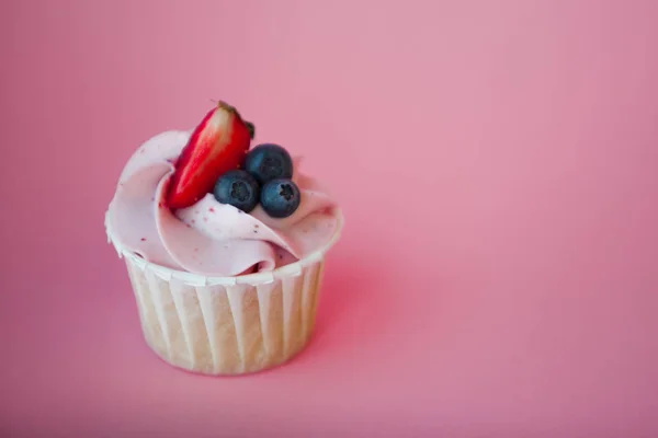 Doce sobremesa no fundo rosa, espaço de cópia. Cupcake com creme, bonito e delicioso . — Fotografia de Stock