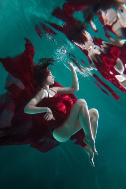Kırmızı elbiseli güzel bir kadının mistik sualtı portresi..