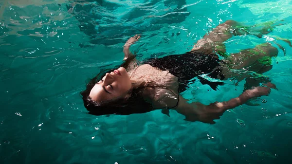 Красивая девушка расслабляется в бассейне СПА, расслабляется и заботится о себе. — стоковое фото