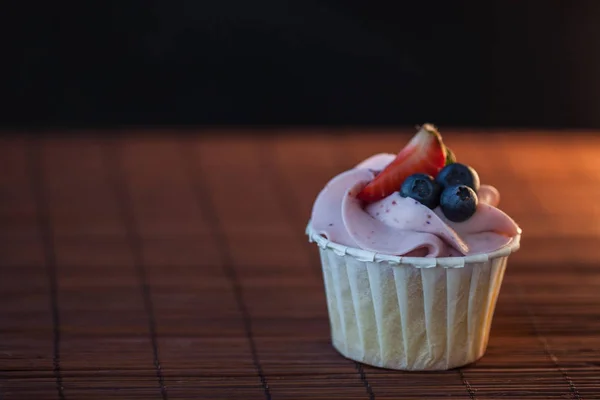 Bonitos e deliciosos cupcakes na mesa. Sobremesa doce com bagas e nata . — Fotografia de Stock